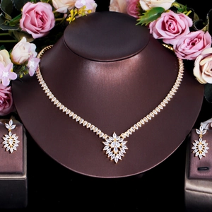 Détail de la parure de bijoux dorée avec zircons taille marquise sur présentoir pro
