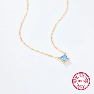 Macro shot of S925 sterling silver gold chain with a square blue zircon pendant