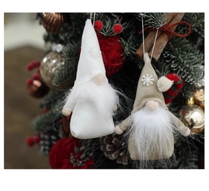 Close-up of felt Christmas gnome ornaments with snowflake patterns on a Christmas tree