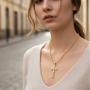Nahaufnahme von vergoldetem Kreuzanhänger mit Zirkonia-Besatz an einer eleganten Kordelkette
