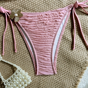 Pink ruched bikini bottom with side ties, gold flower charm and pearl detail