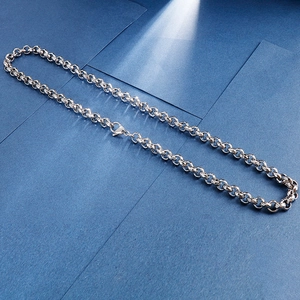 Détail d'un collier en chaîne d'acier inoxydable argenté avec fermoir mousqueton sur bleu