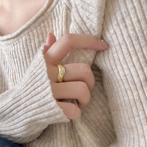 Minimalist 925 sterling silver curved ring with smooth gold finish on model's hand