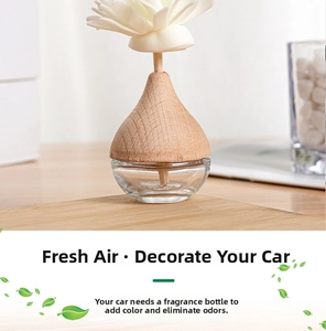 Close-up of glass reed diffuser bottle with wooden stopper and white flower topper
