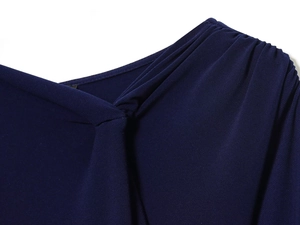Detail of navy blue pleated shoulder design with fine knit texture and refined draping