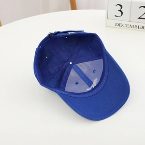 Broderie détaillée d'un dinosaure blanc sur une casquette de baseball bleu roi