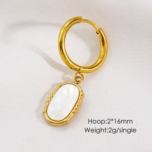 Detailed macro view of 16mm gold hoop earring with white oval natural stone pendant