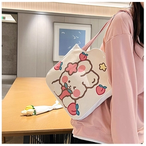 Detail of canvas shoulder bag with cute pink bear and peach pattern on cream fabric