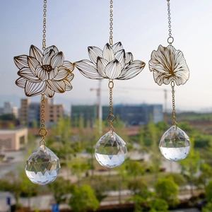 Detail of hanging metal lotus suncatchers with faceted crystal balls in natural outdoor light