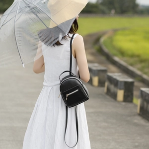 Fashionable black leather mini backpack for women styled on a professional model outdoors