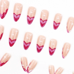 Almond press-on nails with nude base, rose red hearts, and white starburst patterns