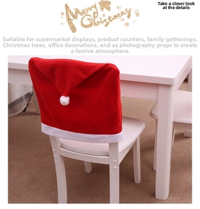 Detail of red Santa hat chair cover with white pompom on a wooden chair for Christmas