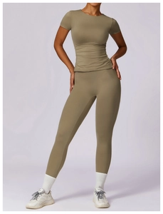 Close-up of olive green slim-fit yoga t-shirt and high-waist leggings on a model