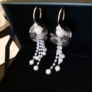 Detail of silver long tassel earrings with sparkling crystals and elegant white pearls