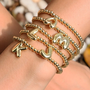 Stack of five 18k gold plated brass beaded bracelets with alphabet and heart charms