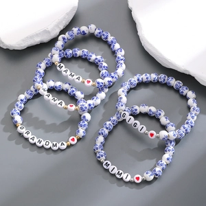Dettaglio di bracciali in porcellana bianca e blu con scritte familiari Nana e Mama