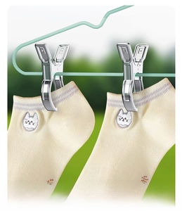 Detail of stainless steel clothes pegs fixing socks onto a hanger with a strong grip