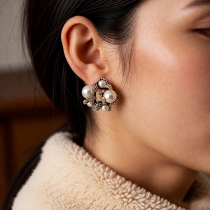 Dettaglio di orecchini vintage a fiore con perle e cristalli sull'orecchio di donna