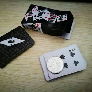 Miniature playing cards set in black box with tiny cards compared to a coin on wood
