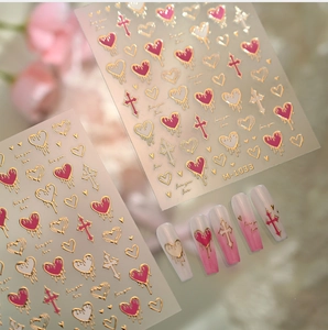 Macro detail of M-1033 heart and cross nail art stickers with gold foil accents