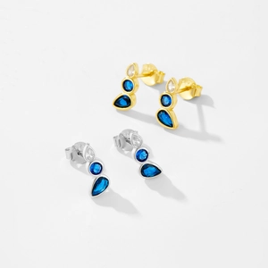 Macro detail of S925 silver water drop earrings with blue gemstones in gold and silver