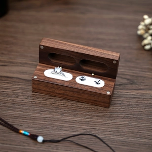 Macro shot of walnut wood jewelry box featuring ring slots and natural wood grain finish