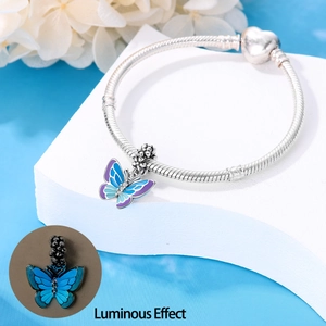 Luminous silver butterfly charm on snake chain bracelet with heart clasp detail