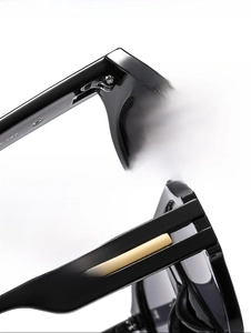 Detail of high-strength metal hinges and golden rectangular decor on black frame temples