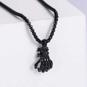 Gothic skull claw hand pendant in matte black titanium steel on white background