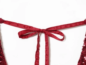 Detailed view of red sequin V-neck dress with elegant satin drawstring detail on white backdrop