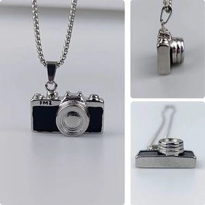 Detailed views of a silver camera pendant necklace featuring the FM2 model design