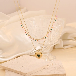 Vue détaillée du collier double couche doré avec pendentif cœur et perles colorées