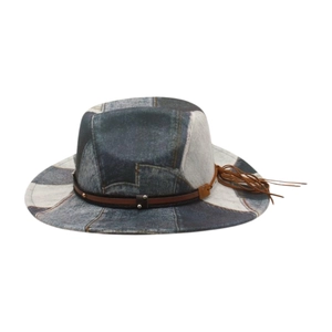 Detail of blue denim patchwork cowboy hat featuring brown leather belt and tassel