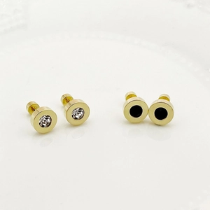 Detail of gold-plated stud earrings featuring white cubic zirconia and black enamel inlay