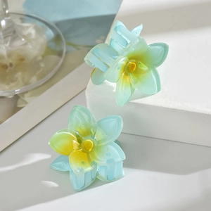 Blue and yellow gradient flower hair claw clips displayed on minimalist white stone steps