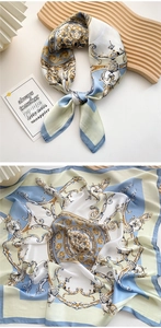 Detail of baroque silk square scarf featuring gold floral patterns on light blue satin