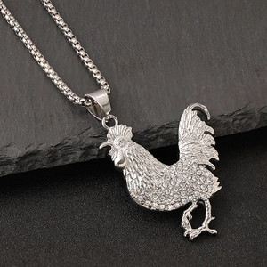 Pendentif coq hip-hop en acier avec strass brillants sur socle en pierre sombre
