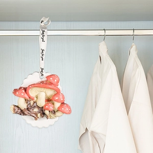 Décoration suspendue champignon rouge et blanc avec ruban Just for you dans un placard