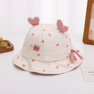 Détail d'un chapeau bébé avec motifs cœurs roses, décor 3D et texture côtelée douce