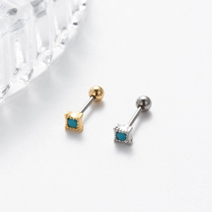 Macro shot of gold and silver stud earrings with square blue stones and screw backs