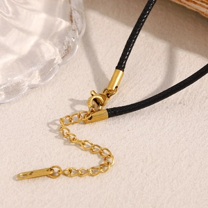 Macro detail of 18K gold plated lobster clasp and adjustable extension chain on black cord