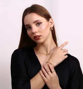 Detailed view of 18K gold-plated daisy necklace with matching jewelry set on a model