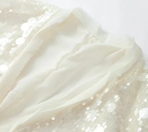 Detailed view of sequin stitching and sheer mesh layering on ivory white women blouse
