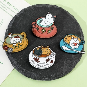 Detailed view of four cute enamel cat coffee cup pins on a black slate base