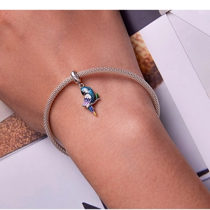 Détail d'un bracelet en maille d'argent S925 avec un pendentif perroquet en émail coloré