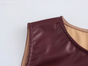 Detail shot of burgundy PU faux leather shoulder seam with smooth beige inner lining