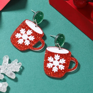 Close-up of festive acrylic Christmas mug earrings with glitter snowflake detailing
