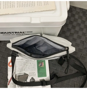 Top view of white nylon messenger bag showing grey interior and metal zipper details