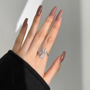 Detail of silver S925 ring featuring leaf design and sparkling cubic zirconia stones