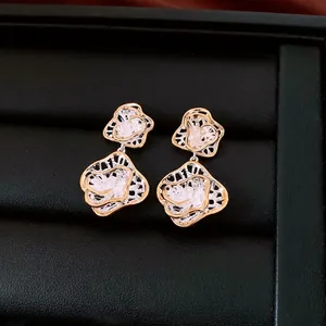Luxury floral hollow drop earrings in gold and silver finish on black jewelry box